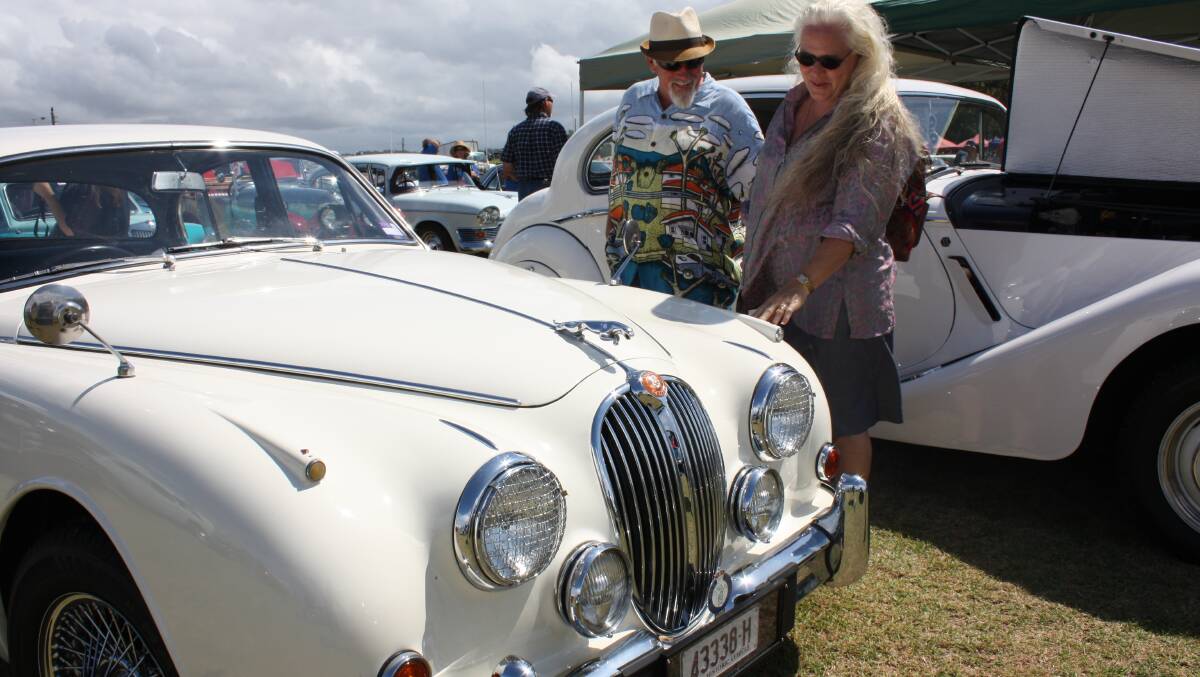 Andrew Whittaker and Victoria Nelson of Bermagui are quite taken with a historic Jaguar on display on Dickinson Oval.