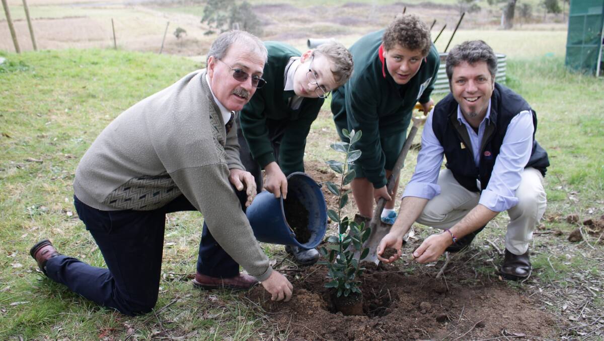 Planting a feijoa in the Sapphire Coast Anglican College Diggers’ Patch are (from left) head of education support Richard Arbon, Year 7 students Riley Triggell-Williams and Mitchell Pearce, and South East LLS Landcare and landholder support officer David Newell. 