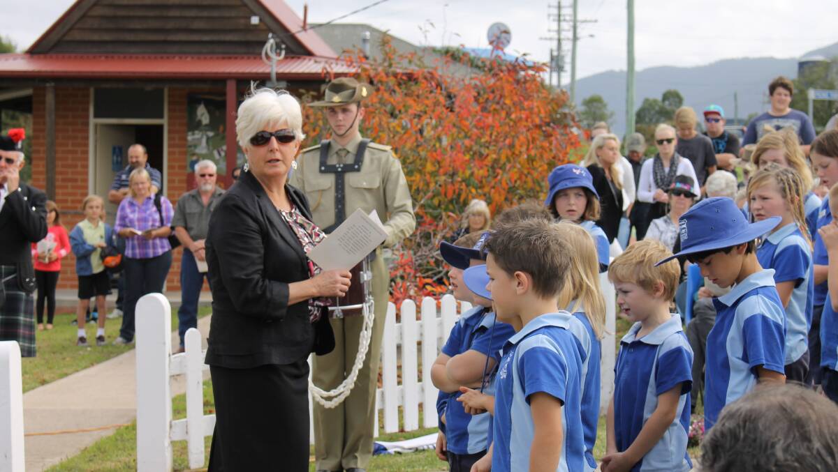 Principal of Bemboka Public School Jan Rogers leads the children in song at the Bemboka Anzac Day commemorative service.