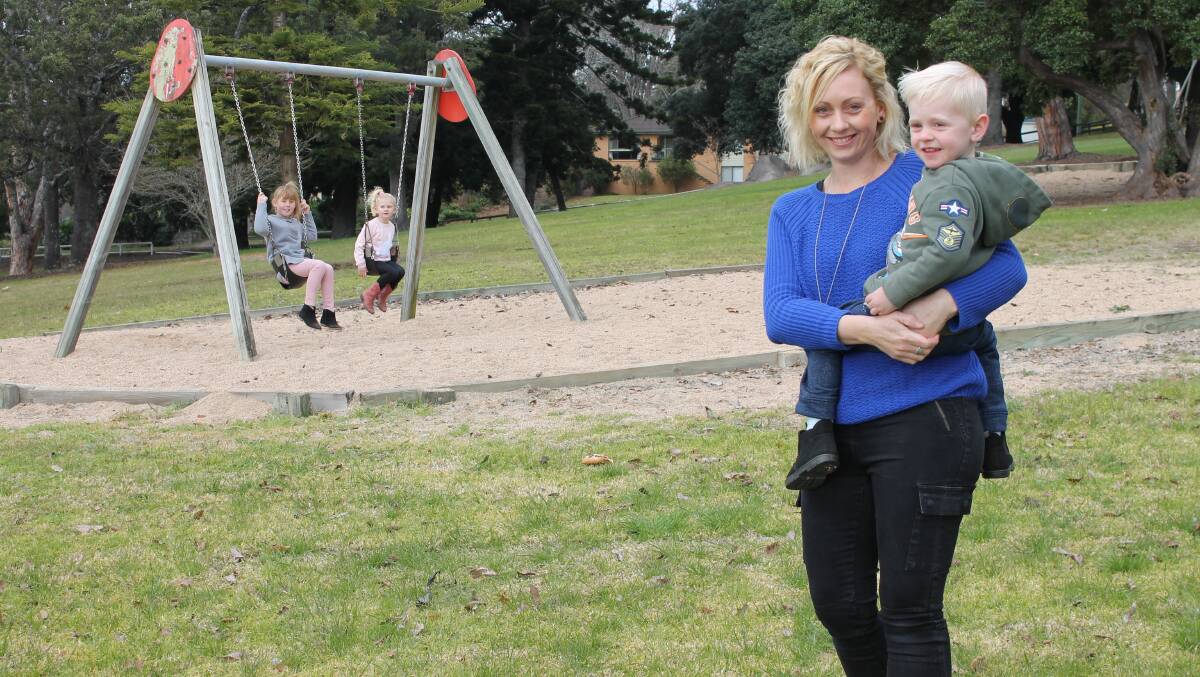 Bega mother Kirsty Umbers, with son Lawson, looks on as her daughters Bridie and Evie make use of the swings in Bega Park – all that remains after outdated and unsafe play equipment was removed. Ms Umbers is one of a group of parents pushing for a new playground in Bega.