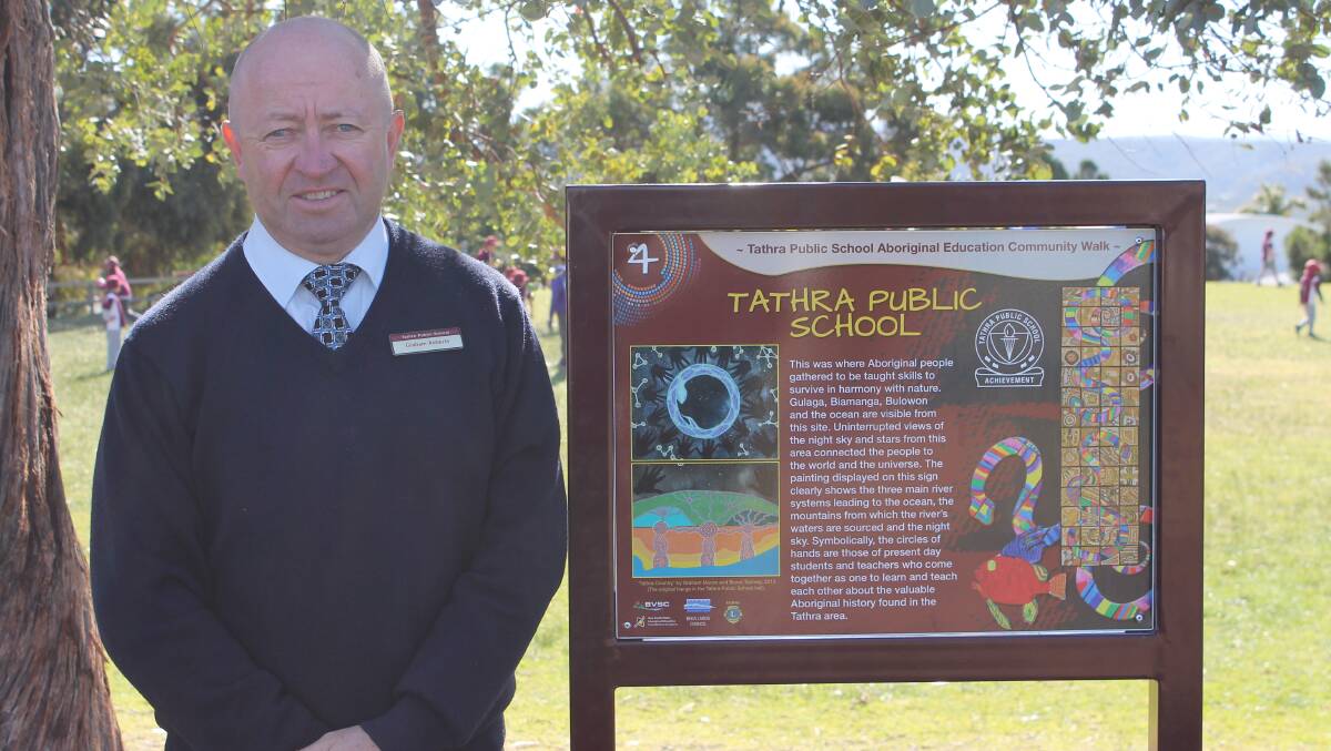 Tathra Public School principal Graham Roberts next to one of the signs along the new walk. 