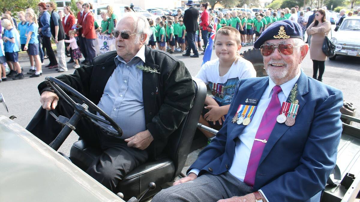 Norm Allan (left), Aden Hawker, and Ewan Munro ride a jeep during the parade. 