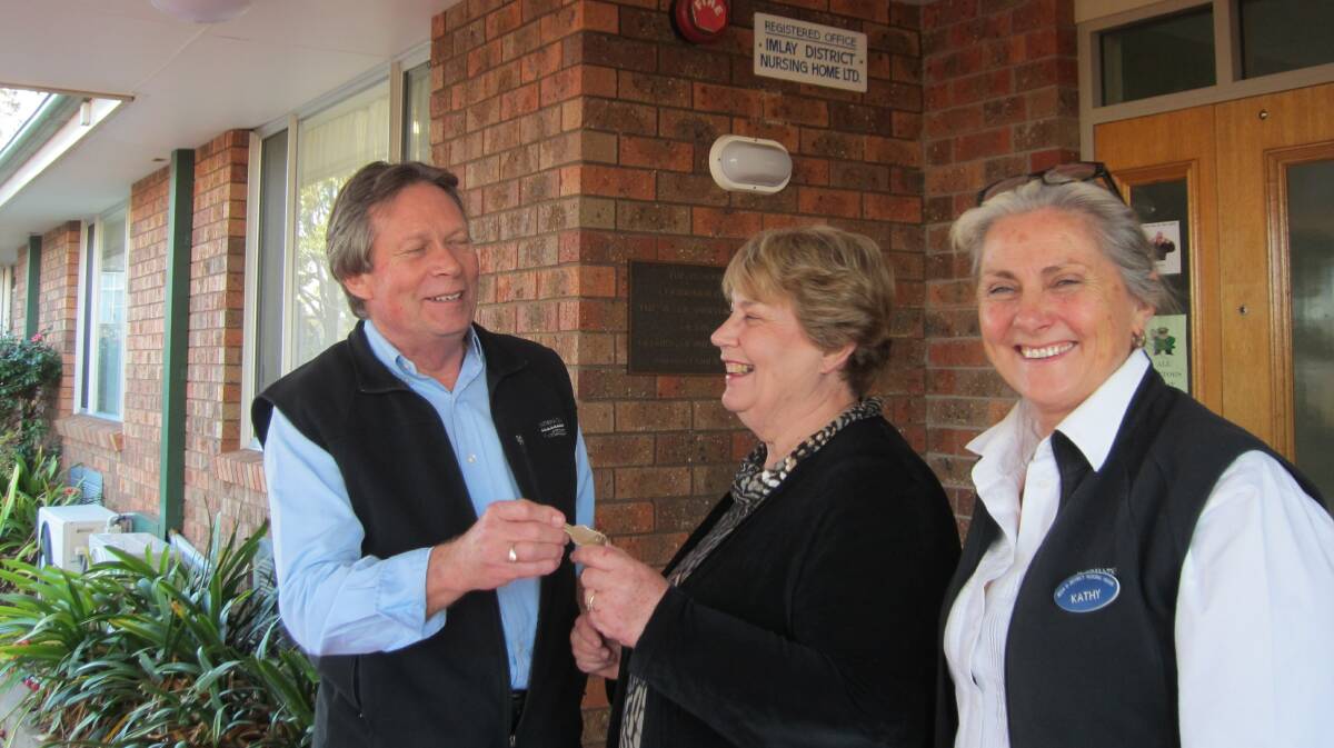 Retiring general manager Helen Ellwood (centre) hands over the keys to Imlay House to Bega Disitrct Nursing Home CEO Jim Butterworth and director of care Kathy Miller.