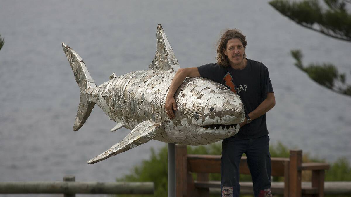 Artist Brett Martin (Congo) with his creation "Protection" many out of tin cans.