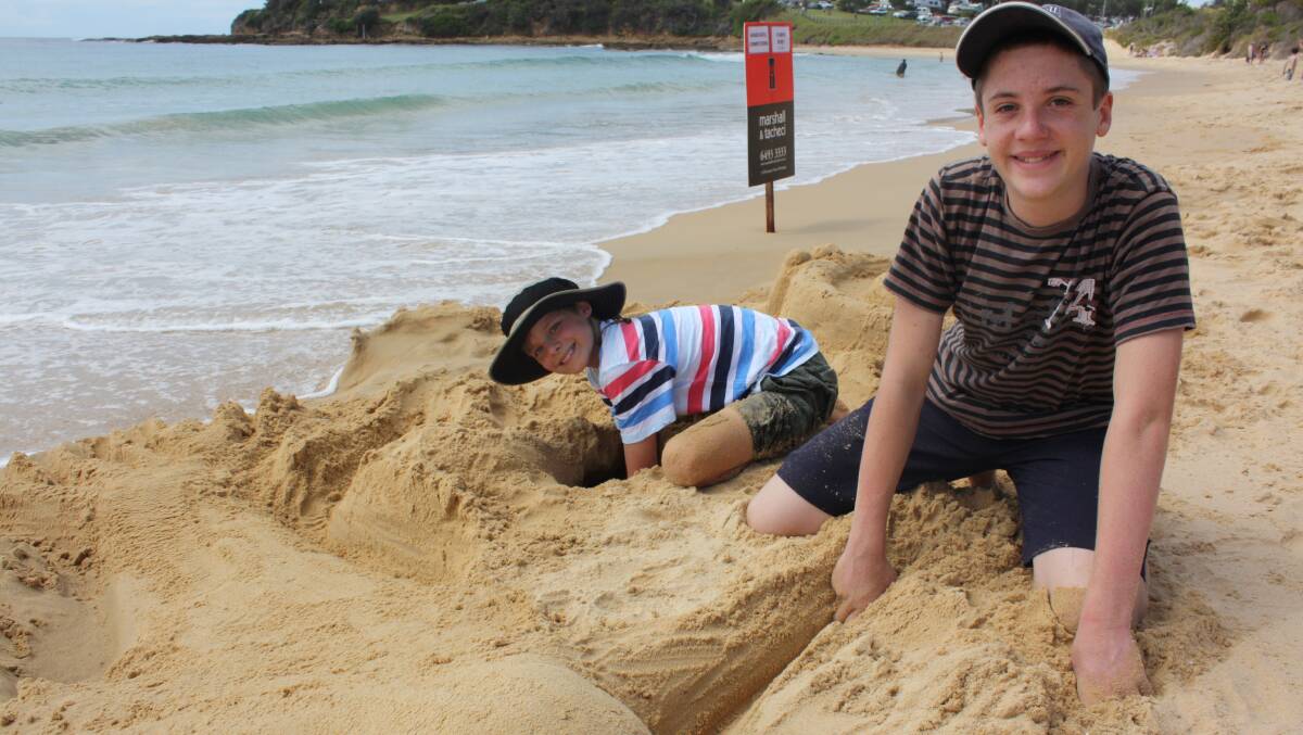 Rushing to complete their entries for the sandcastle competition before the tide comes in are Sakari Kontiainen and Elijah Buchli.