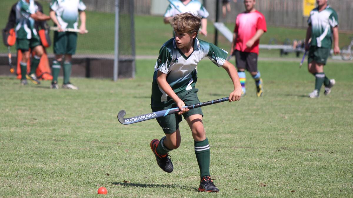 PAMBULA: Lachlan Sims scoops up the ball for his Pambula hockey team on Saturday. 