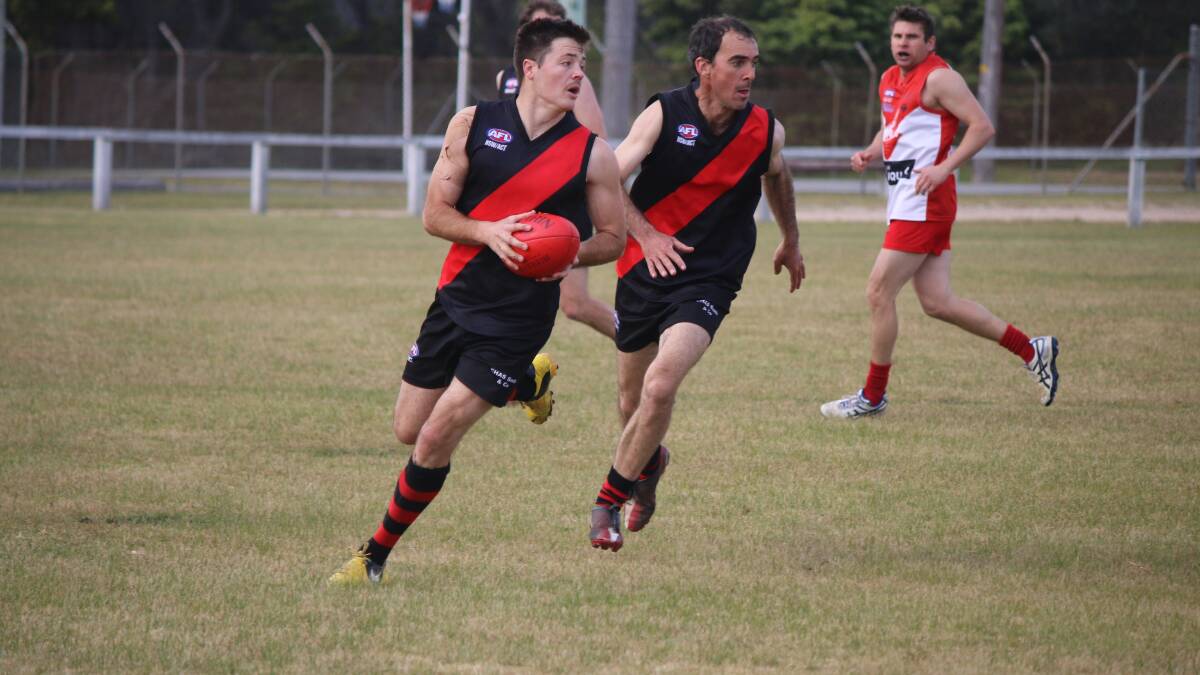• Scott Hay runs the ball up with support from Dan Blacka during the Bombers’ 105-point flogging of the Eden Whalers on Saturday. 
