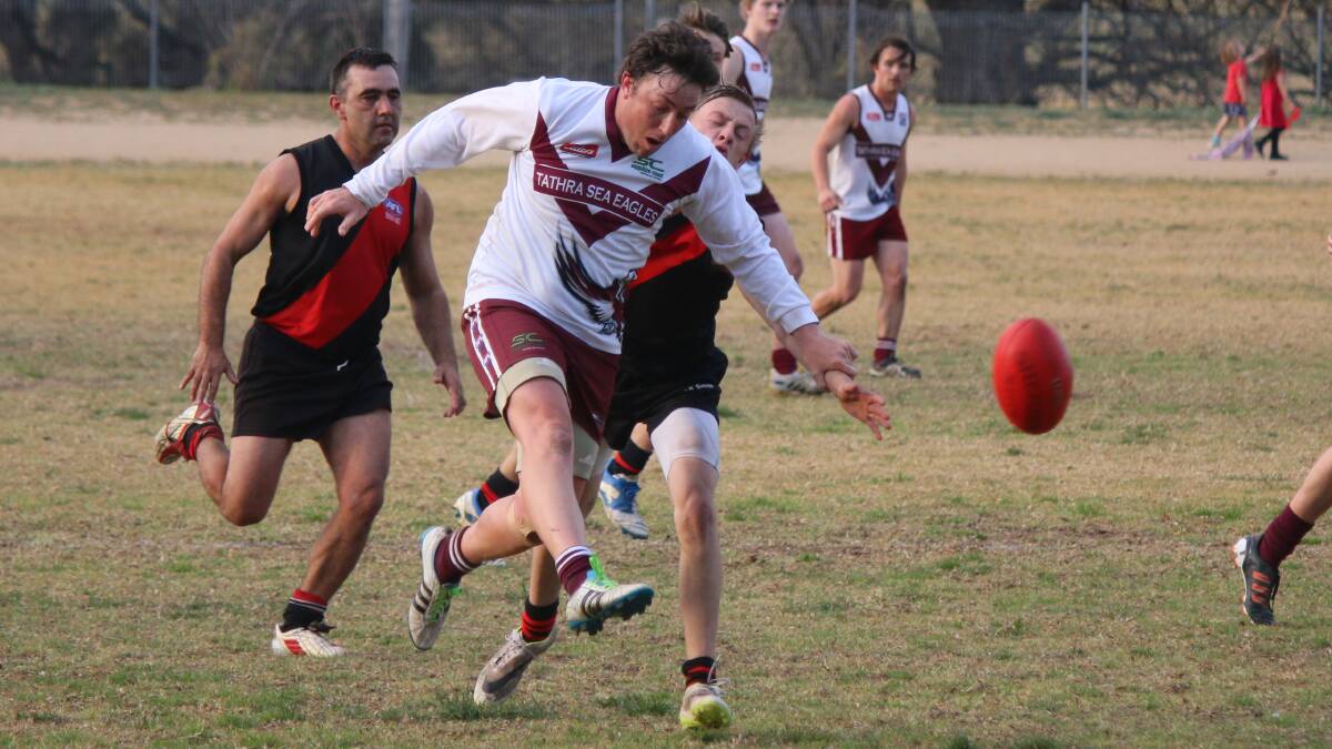Tathra Sea Eagles veteran Luke Taylor pictured kicking to a team-mate during a match last year is excited about the Nines tournament and the launch of the AFL season. 