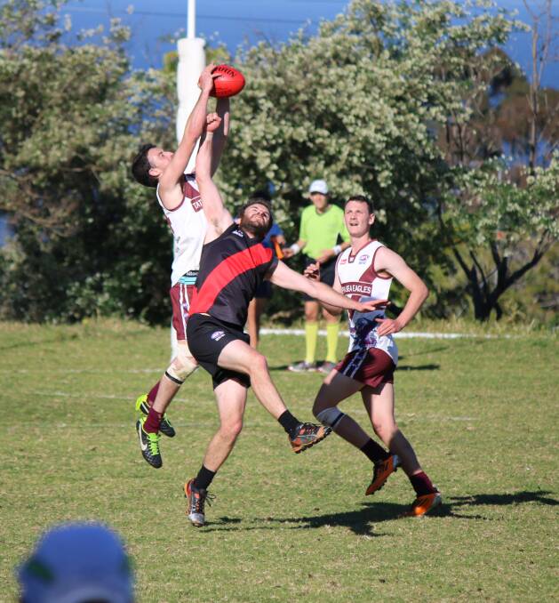 • Sea Eagle Ryan O’Loghlin takes a stunning mark with support from Bayden Pilbeam as Bomber Justin Welford tries to punch the ball out on Sunday. 