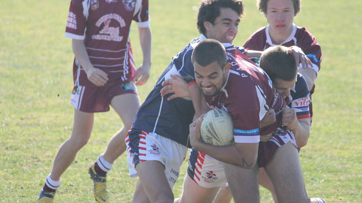 • Sea Eagle Dillon Aldridge gets wrapped up by a pair of Roosters on Sunday. 