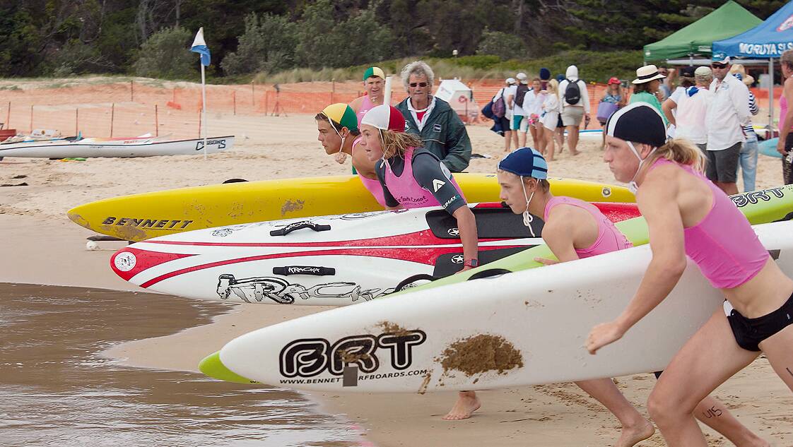 • Competitors prepare to hit the surf in the under 17s board relay event.