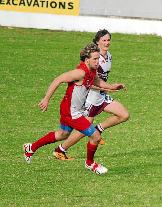 • Bayden Pilbeam (right) runs alongside his Eden Whalers opponent during his first game of Aussie rules last week. 