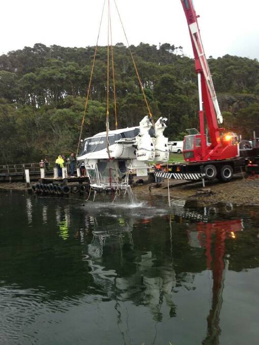 CRANE LIFT: The crane from Narooma Cranes was used to lift the fishing boat out of the water on Thursday evening finally ending its fateful fishing trip. 