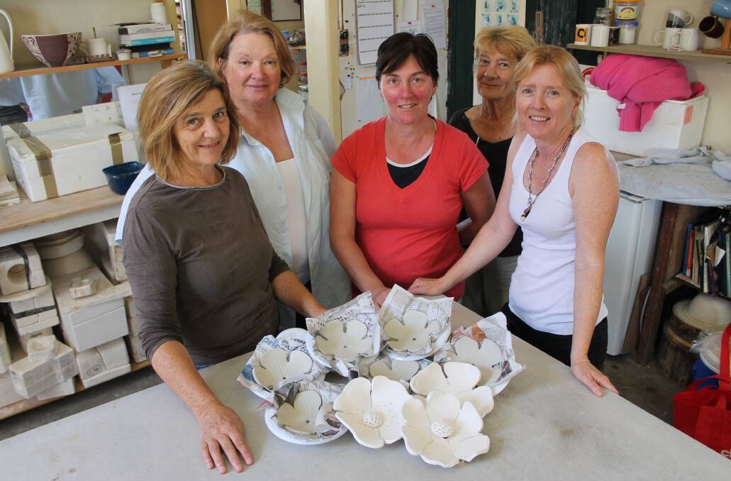 Creating ceramic poppies for the Bega Show opening ceremony are (from left) Narelle Griffin, Prue Kelly, Tanya Pearce, Rhonda Jones and Barb Rogers. 