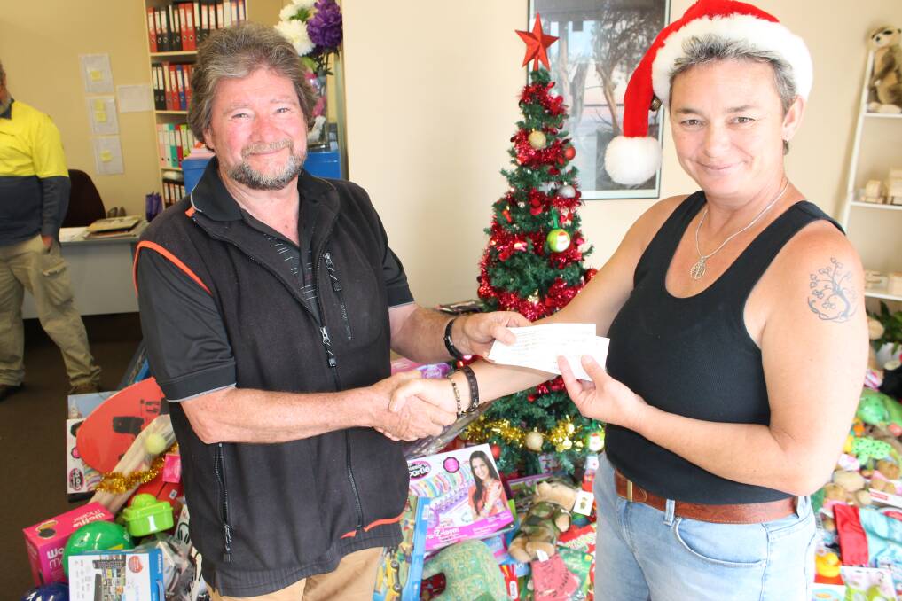 Tony Hergenhan from Bega Vinnies is presented with a cheque by Ulysses Sapphire Coast branch president Kate Spears.