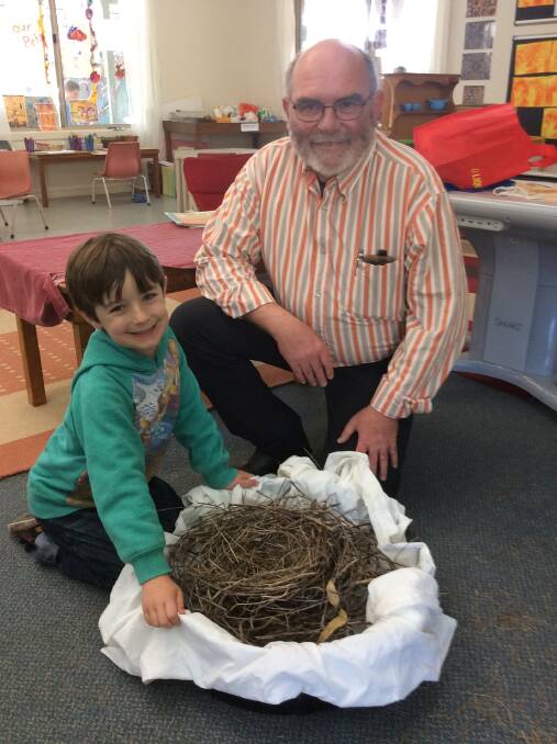 Hayden Kingston from Far South Coast Birdwatchers Inc. shows a nest to Bandara student, Lincoln Morris. The nest inspired the children to create their own from natural materials found in the playground.