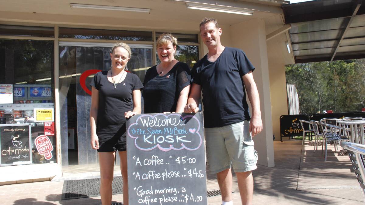 Seven Mile Beach Kiosk head chef Megan Jones and owners Kylie Pickett and Kev Chilver with the sign that has attracted so much attention. Picture: PHIL McCARROLL 