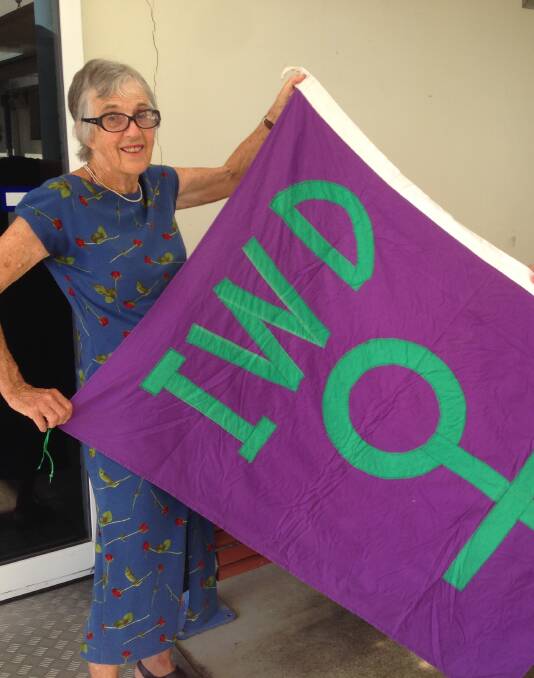 Margaret Sheaves holding an International Women's Day flag.