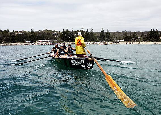 • Michael “Buff” Britten guides the Tathra crew towards a crowded beach at the end of the Bermagui - Tathra leg of the George Bass Marathon yesterday.