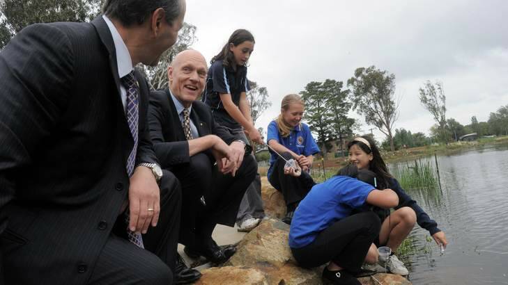 Minister Peter Garrett and US Ambassador Jeffery Bleich, far left, watch students, (from left) Laura Mobini, Annabelle Mill, Angela Wang and Rose Zhang gather water samples at Sullivans Creek. Photo: Graham Tidy