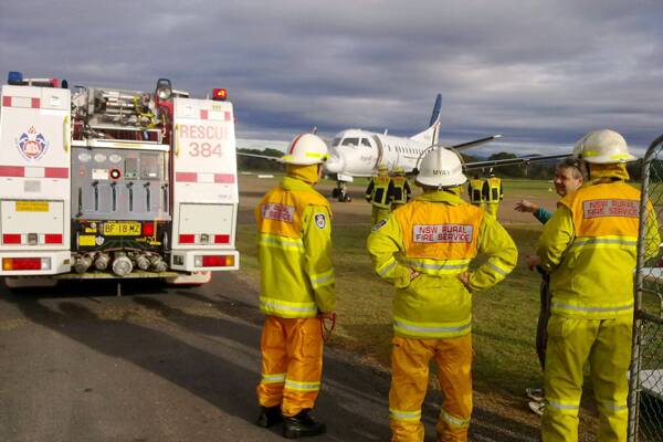 • Rural Fire Service crews and NSW Fire and Rescue personnel inspect a REX plane 
