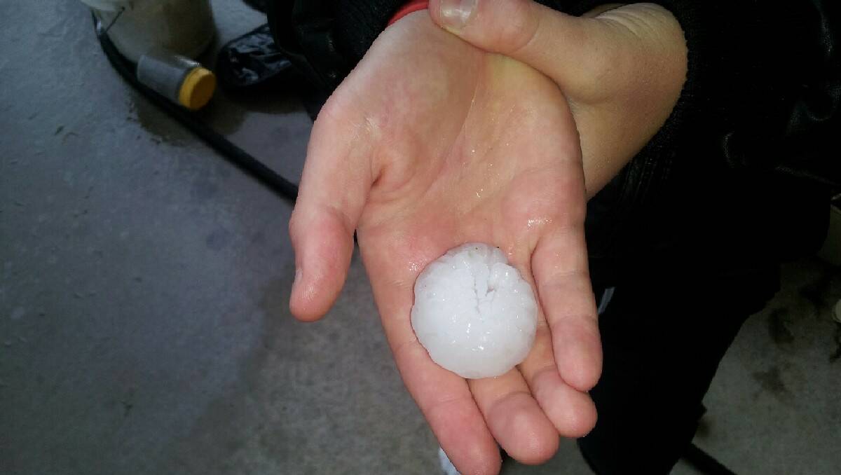 Dylan Cooper holds one of the massive hail stones that fell on his property on Saturday.