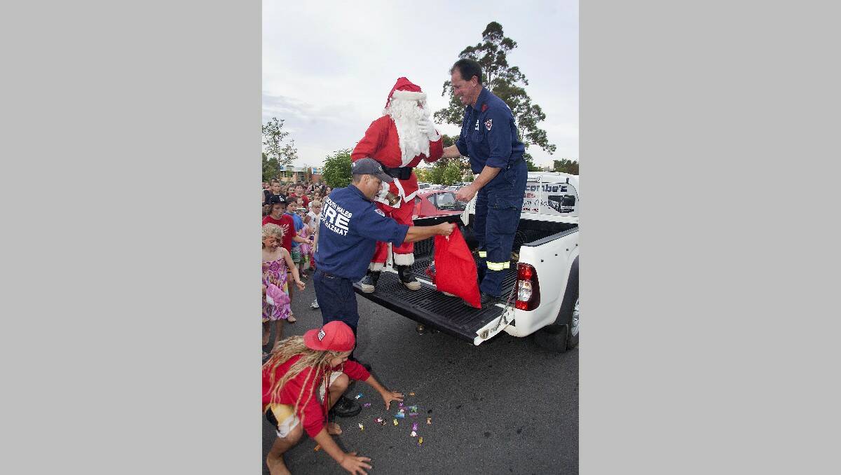 Santa drops his lollies, much to the delight of some waiting youngsters.