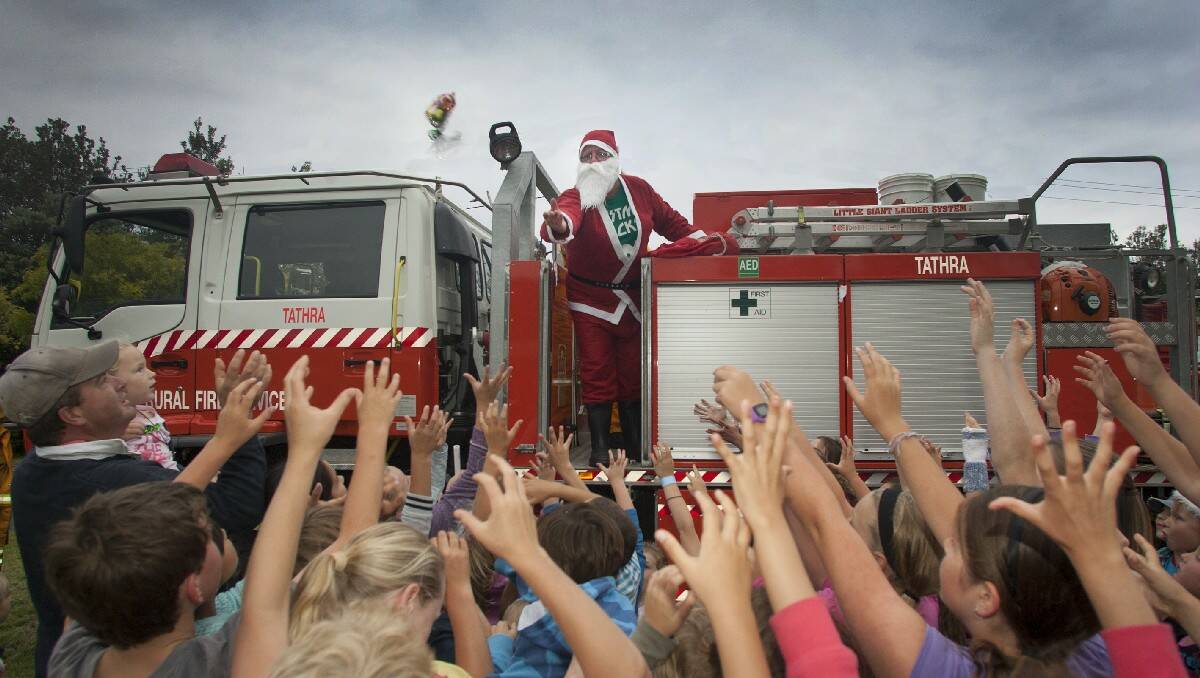 Children scramble for lolly bags thrown by Santa at the Tathra Christmas carols. All photos: Peter Smith.
