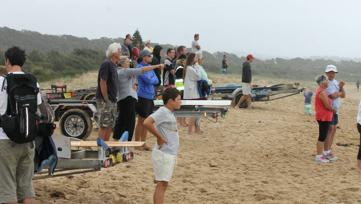 Bega’s Kathy Miller points to the George Bass marathon crews as a large crowd gathers at Tathra Beach.