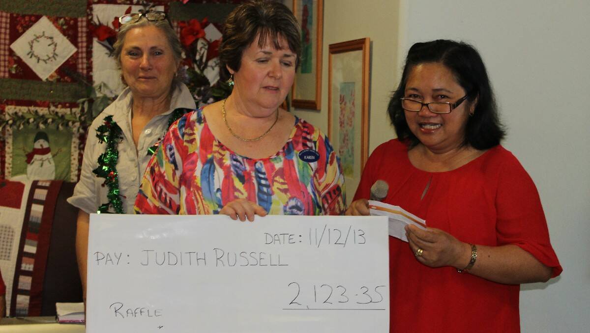 Karen Tett from Hillgrove House reveals the amount raised from a raffle and donations, which will go towards helping the family of Judy Russell (right) in the Philippines following the devastation wrought by Typhoon Haiyan.