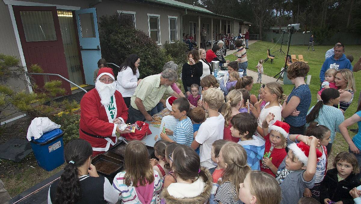 Santa hands out the lollies for the "lollie scramble" at Tathra