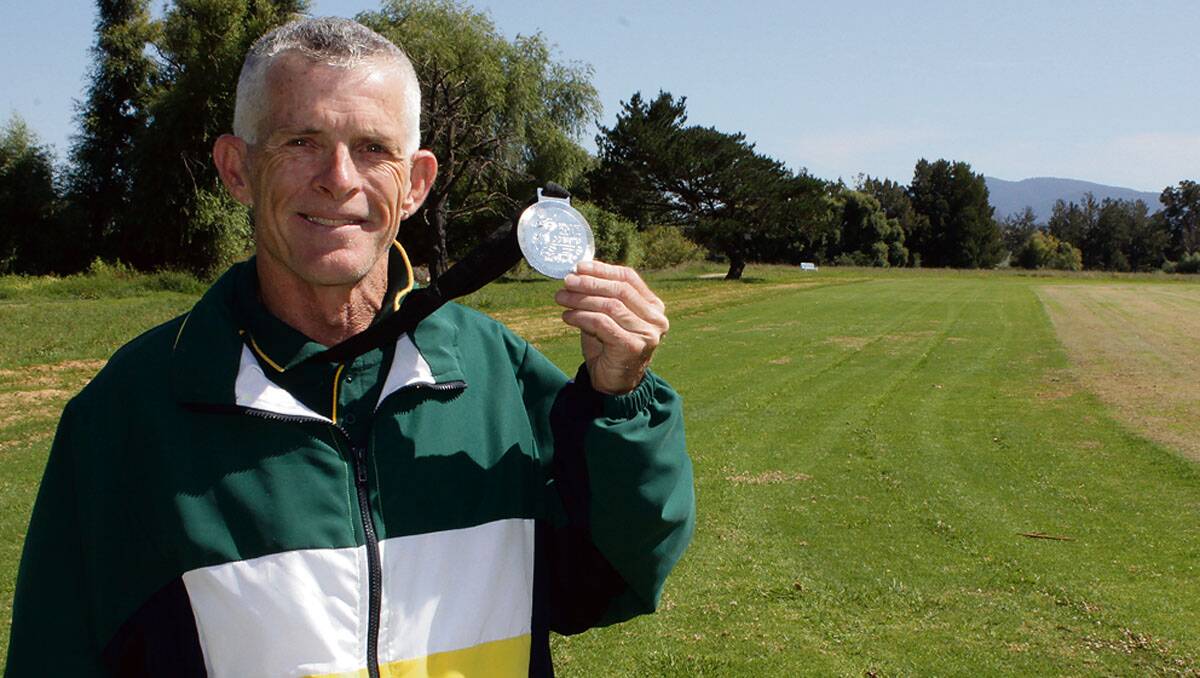 • Keith Law, of Bemboka, shows off his silver Masters medal at the Bega Athletics Field where he trains.