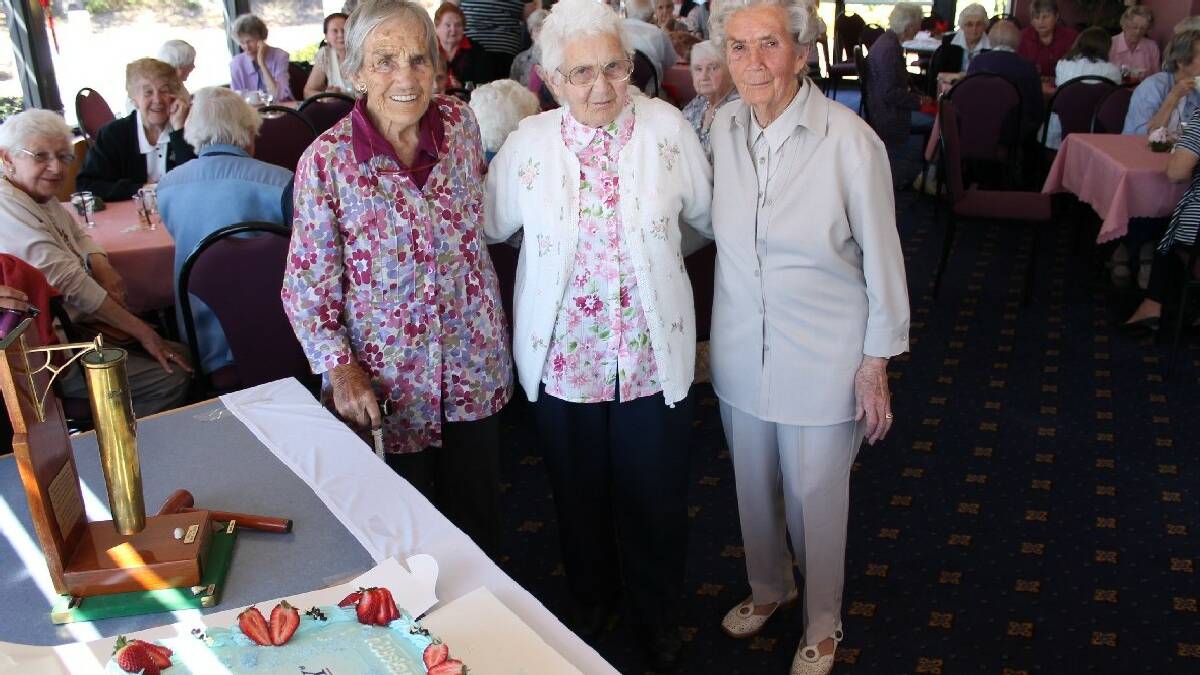 TATHRA: Bega Valley war widows (from left) Joan Cochrane, Nina Smith and Dot Cleaver cut the cake to commemorate the 90th anniversary of the formation of Legacy in   1923 – the same year all three were born.