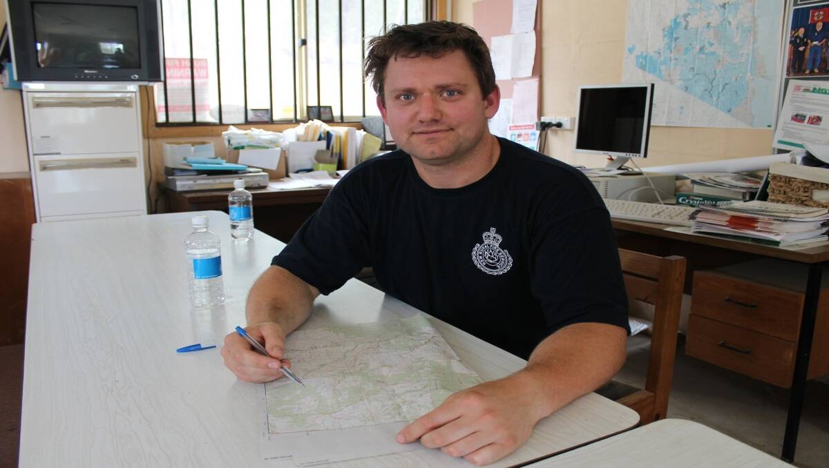 Steve McGinnity from Brogo RFS looks at a map of the affected area as the RFS makes plans to defend threatened homes