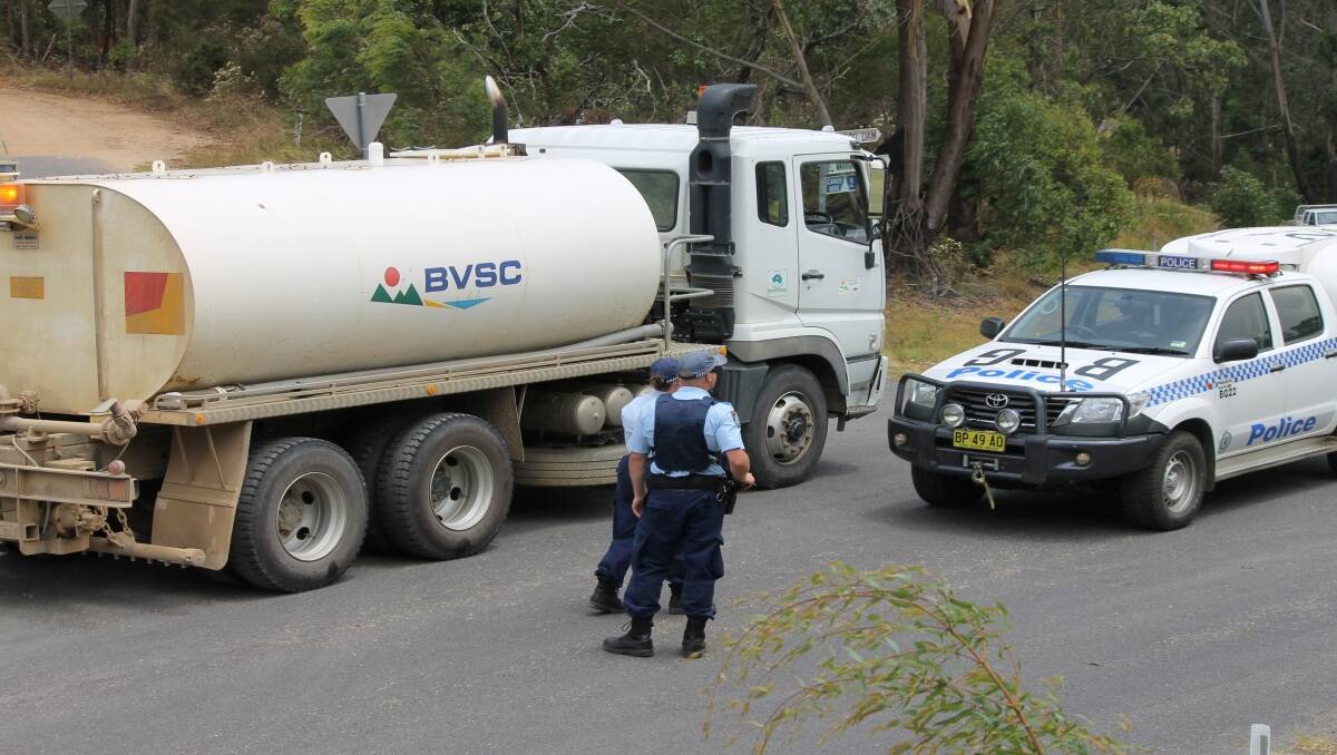 Bega police talk to a water tanker driver from Bega Valley Shire Council. Water trucks have been back and forth along Warrigal Range Rd in Bega throughout the morning.  