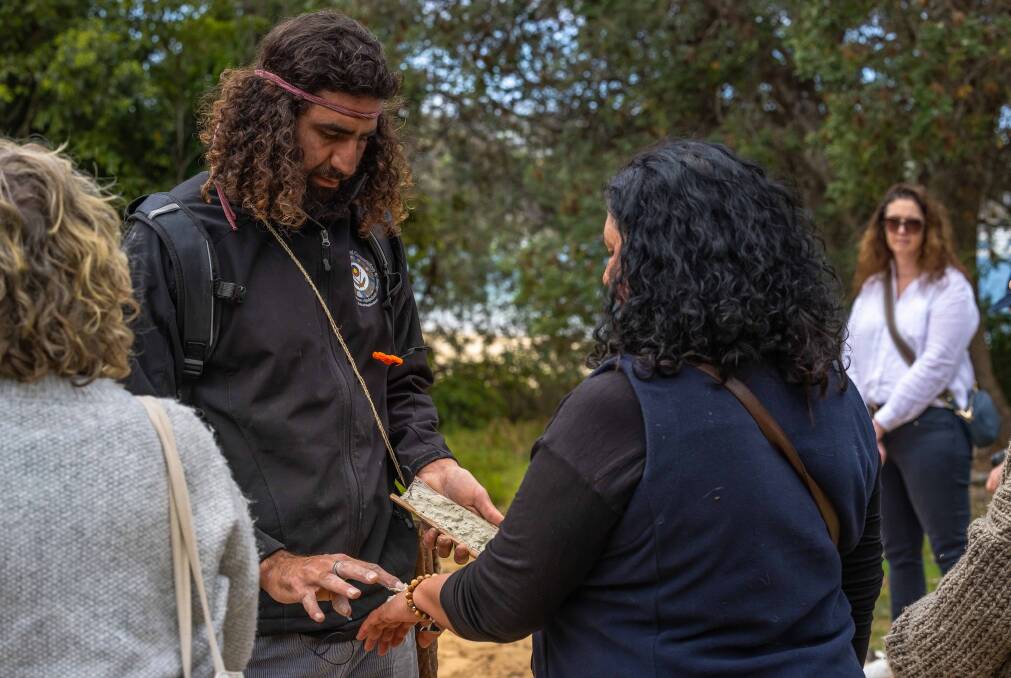 Nathan Lygon paints Clair Mudaliar's hand with ochre in the Yandama On Country tour, a business he has recently launched with his wife Rochelle Lygon. Picture by David Rogers. 