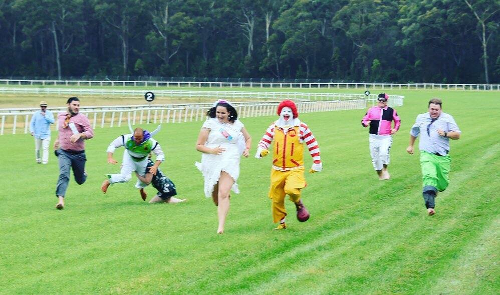 Buzz gets crash tackled by bride's maid of honour in a race with three other grooms and special guest Ronald McDonald at Bendigo Bank Pambula Cup Race Day. Photo: Bradley Photography