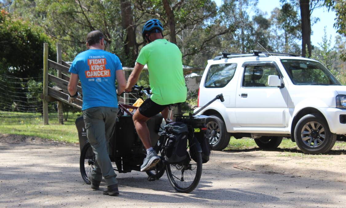 Doug Reckord gives Dane Waites a quick crash course of his powered tricycle that he collects rubbish with. Photo: Amandine Ahrens