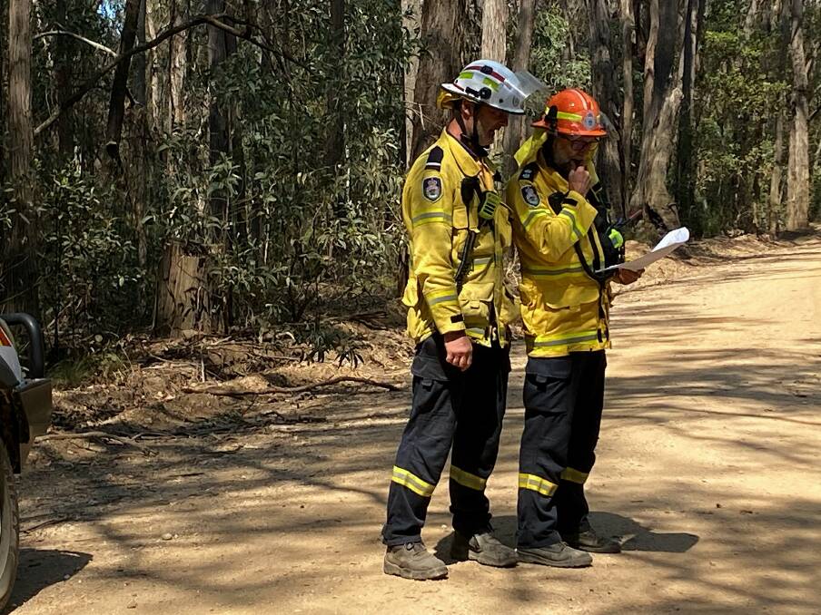 Candelo RFS captain Phil Banks (in the orange helmet) returns to assist the Coolagolite fire on Saturday October 7. Picture supplied. 