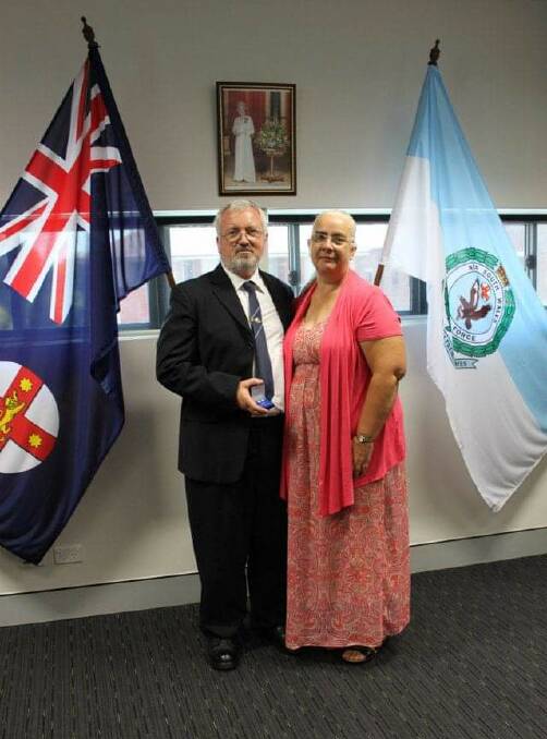 Barry Hayward receives a medal for 25 years of service with the police force, with his wife Linda by his side. Picture supplied. 