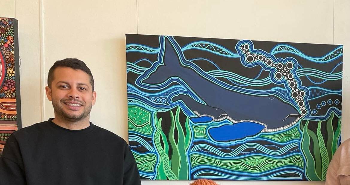 Marcus Mundy standing beside his artwork at Spiral Gallery, Bega. 
