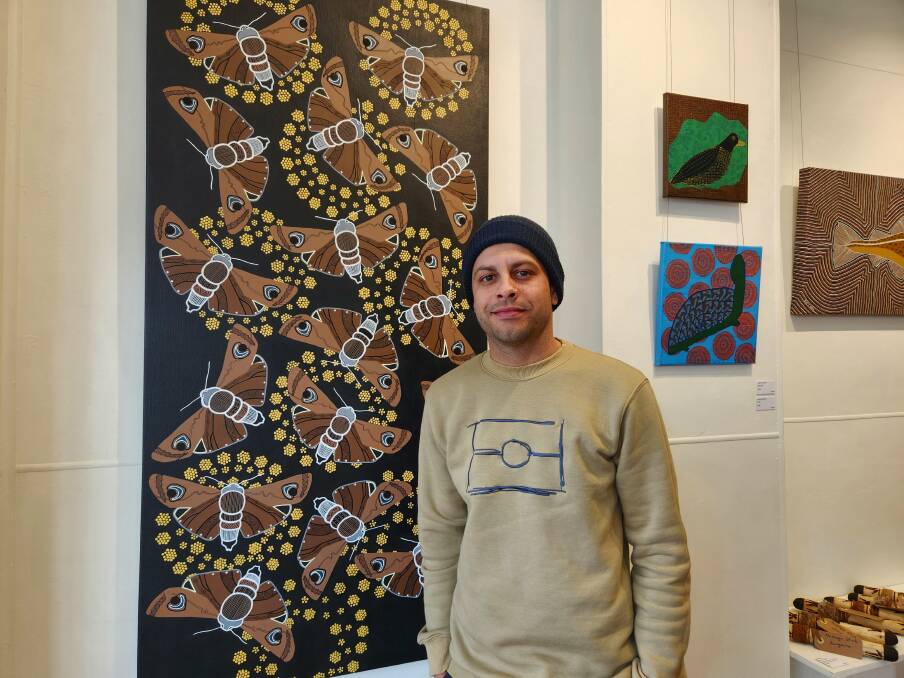 Marcus Mundy presents his and Lucinda Thurston's artwork, 'Bogong Migration' at the South Coast Indigenous Artists Exhibition at Spiral Gallery Bega on opening day - August 12, 2023. Picture by Amandine Ahrens 
