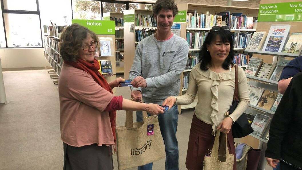 Looking back: Bega Valley Shire library services coordinator Megan Jordan-Jones takes delight in handing over a library bag to two new members of the library, September 2018.