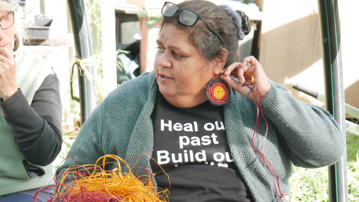 South Coast Yuin artist Cheryl Davidson holds up an example of how weaving can be transformed into wearable jewellery pieces. Photo: Ellouise Bailey