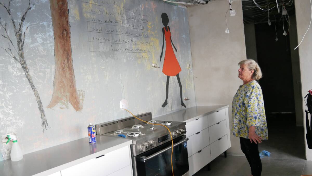 Ms Van Doorn stands in front of the mural she is in the process of creating on her new kitchen wall. 