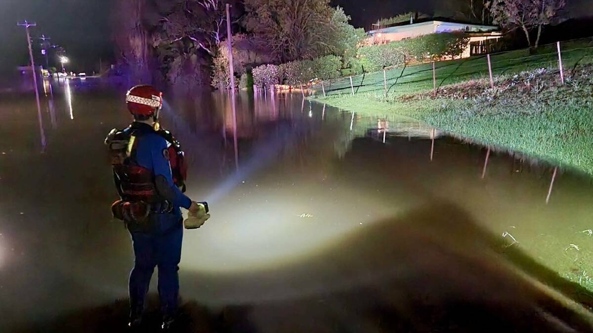 An SES worker judging flood waters during a rescue mission. 