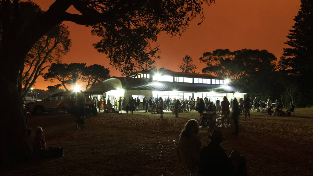 People gathered around and within Bermagui Surf Life Saving Club during the Black Summer Bushfires. Photo: Andrew Worssam