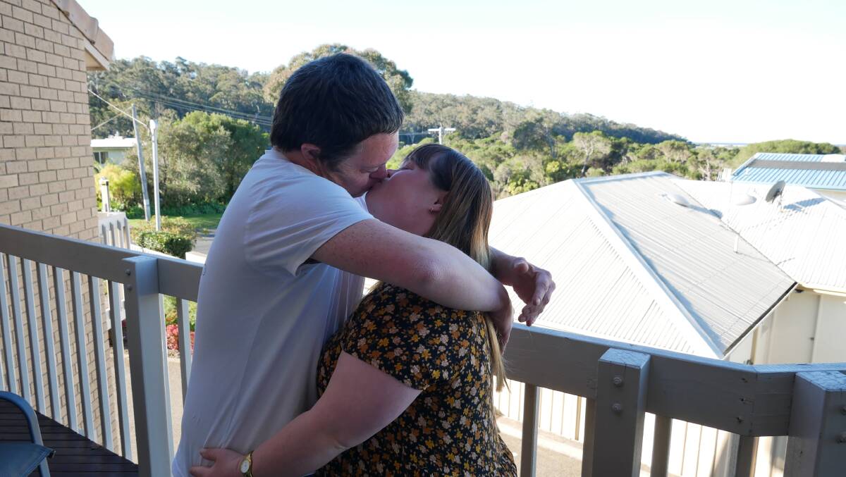 Tim and Amanda share a kiss on the balcony of their flat in Merimbula. 