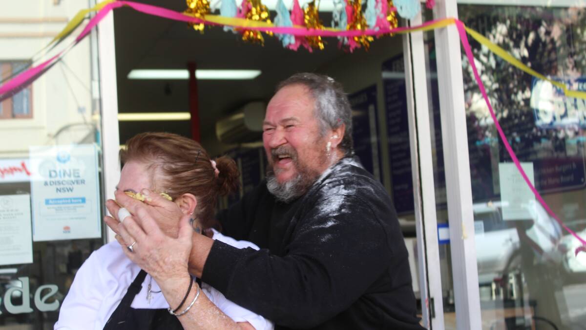 Michelle Brown gets a custard tart to the face as a good luck farewell from previous owner Ken Woods. Ms Brown will rename the cafe Ellie Mae's Cafe and Bakery. 