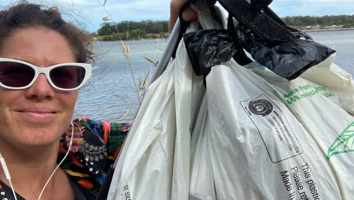 Kate Liston-Mills with a bag of rubbish she collected along the Merimbula foreshore. She said the lakeside was particularly dirty after the float that occurred on Australia Day. Photo: supplied 